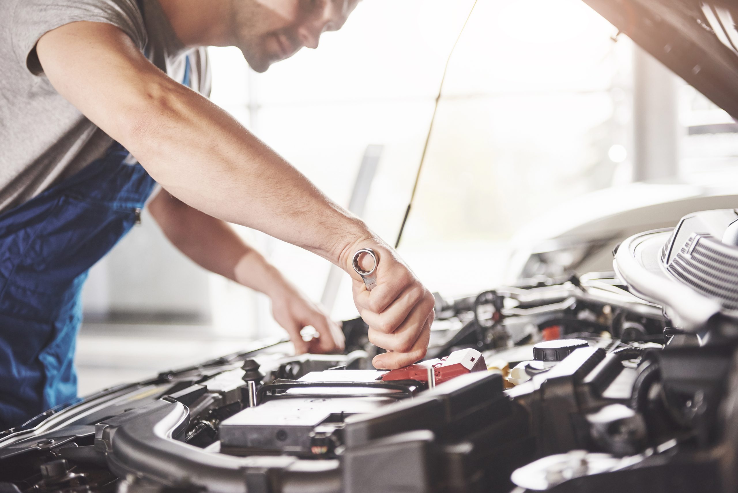 Auto mechanic working in garage. Repair service.