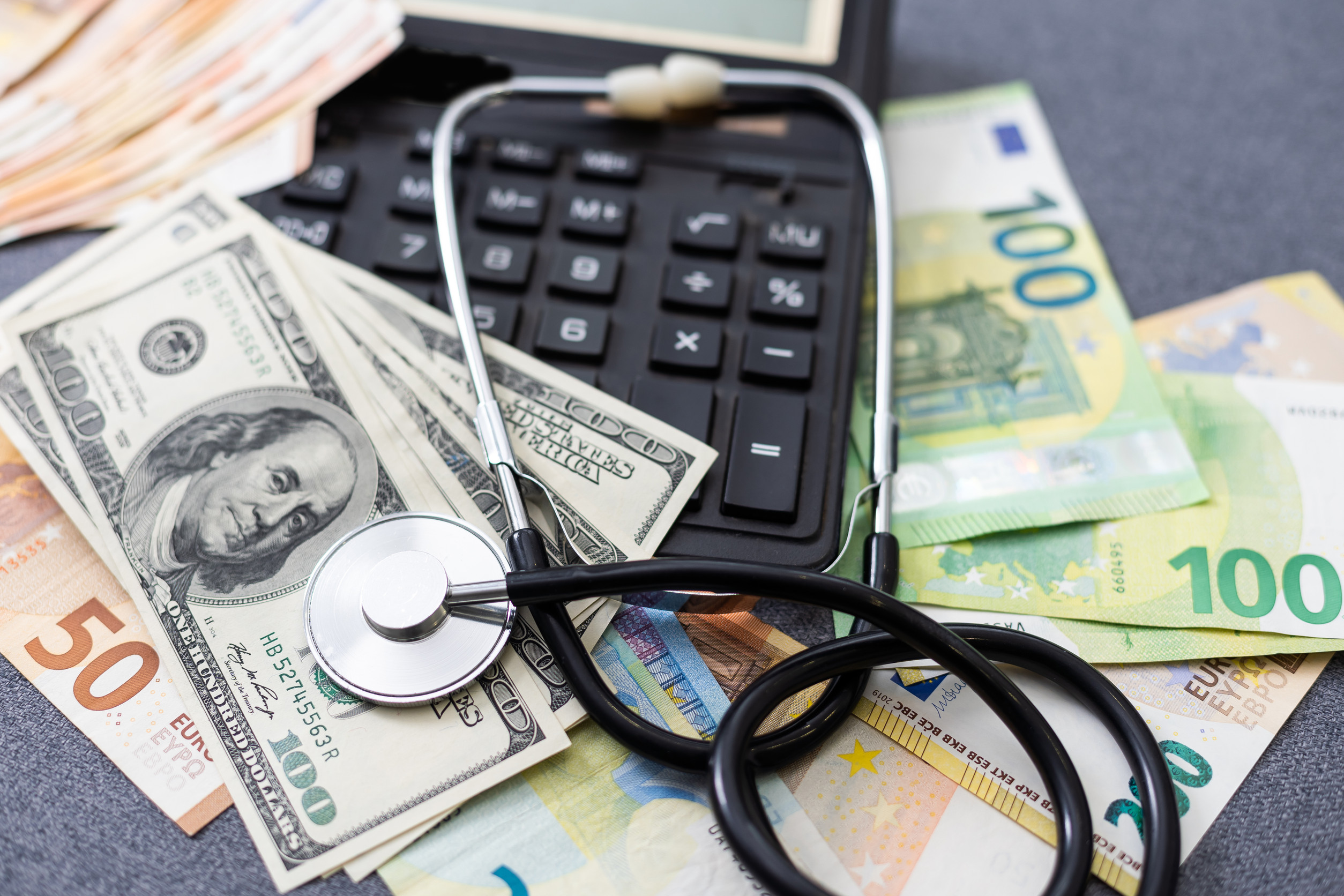 stethoscope over euro banknotes symbolize the cost of health care concept on the white background. High quality photo