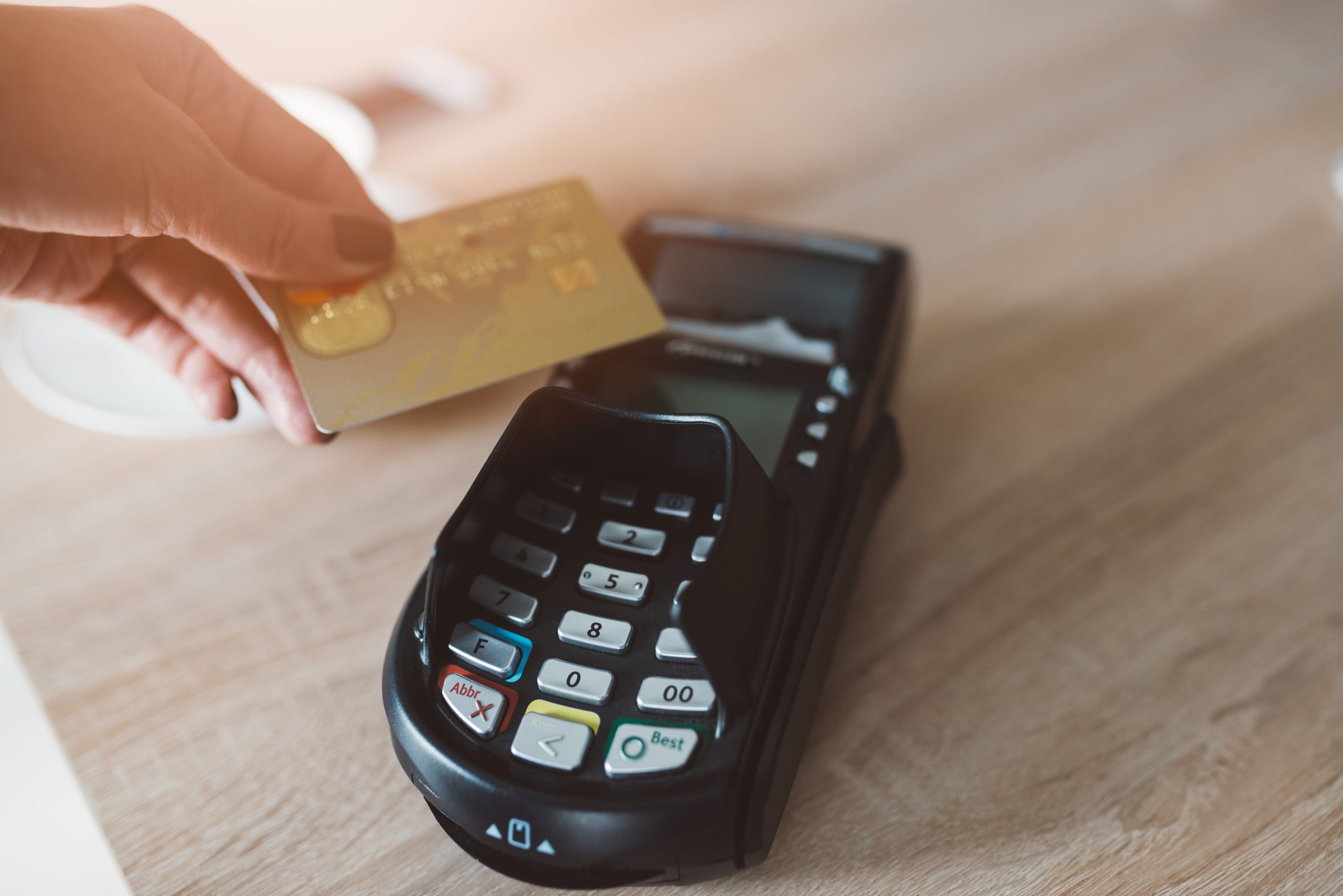 Woman paying with contactless credit card in cafe