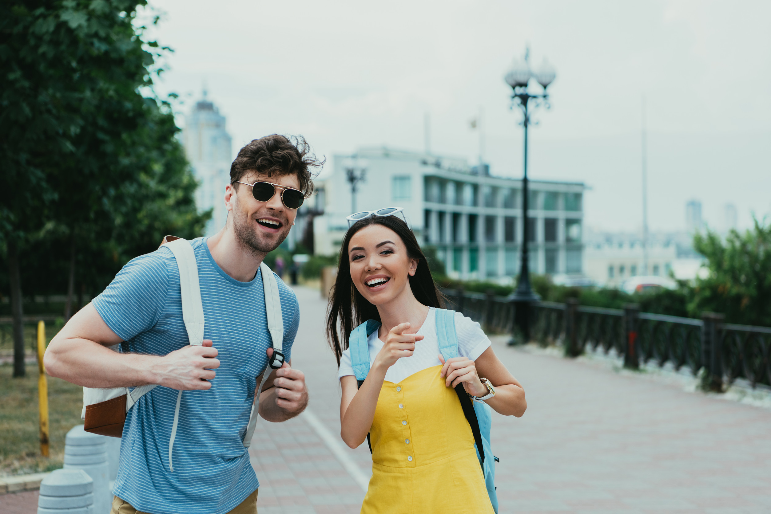 handsome man looking away and asian woman pointing with finger