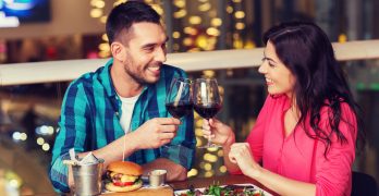 leisure, celebration, food and drinks, people and holidays concept - smiling couple having dinner and drinking red wine at date in restaurant